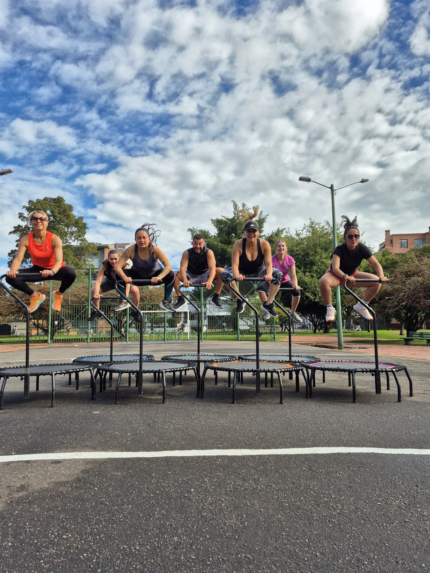 Grupo saltando en trampolín al aire libre, celebrando en comunidad